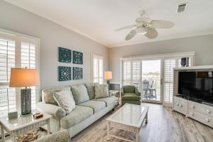 a living room with a couch and a tv at Dolphin Harbor Orange Beach Condo w/ Beach Access! in Orange Beach