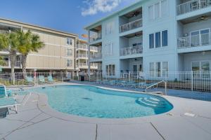 a swimming pool in front of a apartment building at Dolphin Harbor Orange Beach Condo w/ Beach Access! in Orange Beach