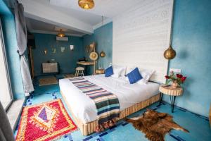 ein Schlafzimmer mit einem großen Bett mit blauen Wänden in der Unterkunft Villa Kamilia Essaouira in Essaouira