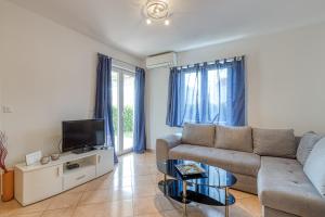 a living room with a couch and a tv at Apartment Mirjana in Karigador in Karigador