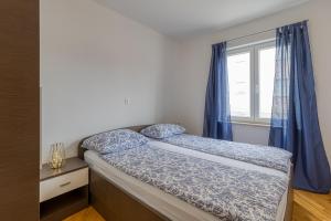 a small bedroom with a bed and a window at Apartment Mirjana in Karigador in Karigador