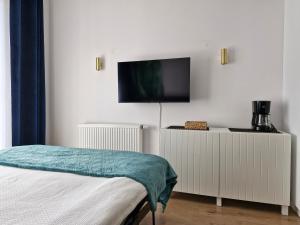 a bedroom with a flat screen tv on a wall at Apartament Levante in Władysławowo