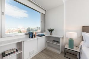 a bedroom with a window with a bed and a desk at Homeclub Apartment at Plaza Colon in Madrid