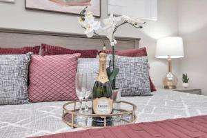 una mesa con una botella de vino y copas en una cama en The Onyx Abode near Kemah Boardwalk!, en Kemah