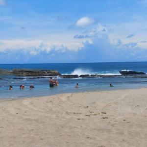 a group of people in the water at the beach at Ache Pa Ti I Isabela in Isabela