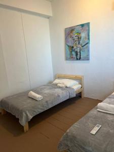 two beds in a room with a painting on the wall at Ache Pa Ti I Isabela in Isabela