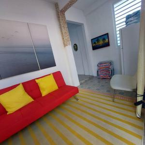 sala de estar con sofá rojo y almohadas amarillas en Ache Pa Ti I Isabela, en Isabela