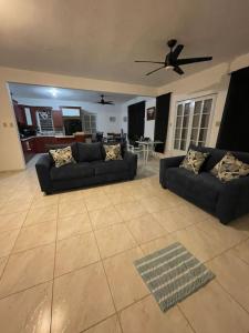uma sala de estar com 2 sofás e uma ventoinha de tecto em Casa familiar en Rincon em Rincon