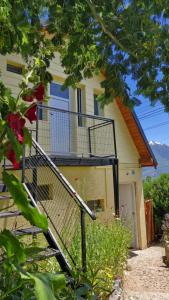 una casa con una escalera delante de ella en La Amarilla Casa de Huéspedes Ruta 40 Montañas en Epuyén