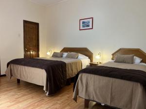 una camera d'albergo con due letti e due lampade di Hotel Escorial a La Serena