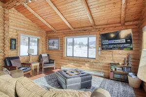 a living room with a couch and a tv at Trout Trap at Henry's Lake in Island Park
