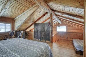 a bedroom with a bed in a wooden cabin at Henry's Lake View Cabin + BBQ + Fire Pit + Decks! in Island Park