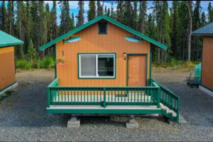 a small orange house with a green roof at Rainbow Trout Retreat, Cabin 5 at Lower Kenai Lodge in Kenai +8 photos