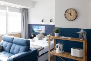 1 dormitorio con 1 cama y reloj en la pared en Apartamentos Salbide Zarautz, en Zarautz