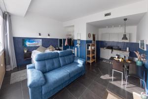 sala de estar con sofá azul y cocina en Apartamentos Salbide Zarautz, en Zarautz