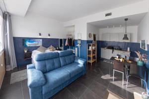 a living room with a blue couch and a kitchen at Zarautz SALBIDE APARTMENTS in Zarautz