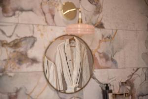 a bathroom mirror with a robe hanging on a wall at Maison Jullian in Béziers