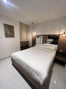 a bedroom with a large white bed in a room at NOVAPARK FERROVIARIA in Guayaquil