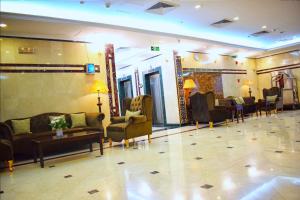 a lobby with couches and chairs and a mirror at وفادة الزهراء in Al Madinah