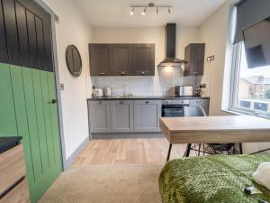 a kitchen with a green door and a table at Comfortable stylish room Pass the Keys in Beeston