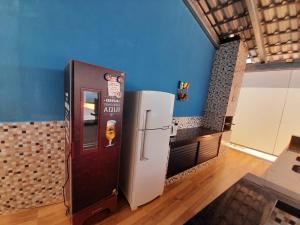 einen Getränkespender in einem Zimmer mit Kühlschrank in der Unterkunft Espaço céu Azul in Ribeirão Preto