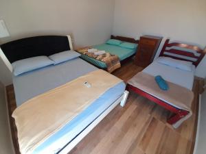 um pequeno quarto com 2 camas e uma cadeira em Espaço céu Azul em Ribeirão Preto