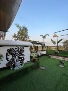 a balcony with a green floor with plants on it at Jacuzzi house with private terrace ambiance in Pune