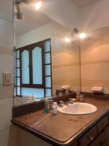 a bathroom with a sink and a large mirror at Casa grande perfectamente ubicada in Cochabamba