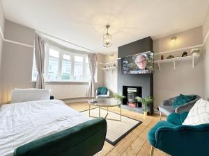 a living room with a bed and a tv at Cosy 3 bed house with FREE Parking near Kingston Thames in Malden