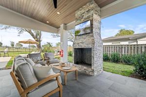 an outdoor living room with a stone fireplace at Taj Duval, Sleeps 14, Pool, Lux in Jacksonville Beach