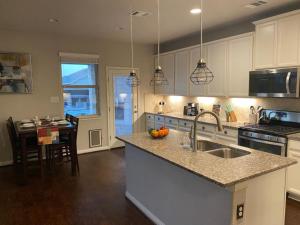 a kitchen with a sink and a counter top at Lxry 4 BR Bckyd, Pool, Hot Tub near attrctns (Tal.) in Helotes