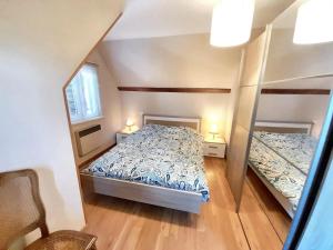 mała sypialnia z łóżkiem i lustrem w obiekcie Maison de charme avec jardin à Ingersheim - Chaleur cosy w mieście Ingersheim
