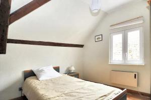 biała sypialnia z łóżkiem i oknem w obiekcie Maison de charme avec jardin à Ingersheim - Chaleur cosy w mieście Ingersheim