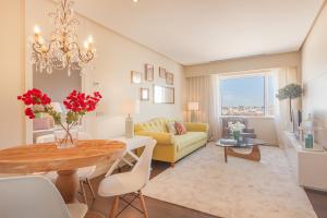 uma sala de estar com uma mesa e um sofá amarelo em Homeclub Exclusive Flat at Madrid Tower em Madri