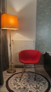 a red chair and a lamp in a room at Métro 8,grand balcon,garage,ascenseur,belle vue pouvoir voir Tour Eiffel in Créteil