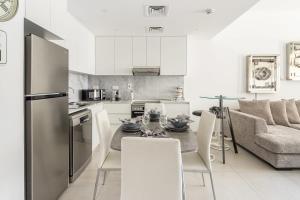 a kitchen and living room with a table and a couch at Frank Porter - Lamtara 2 in Dubai