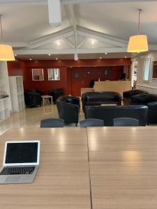 a laptop on a table in a room with chairs at Budget Hotel Melun Sud - Dammarie Les Lys in Dammarie-lès-Lys