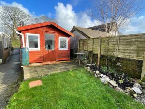 a tiny house in a yard with a fence at Raes Cottage Sleeps 2 plus1 in Camelford