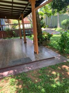 a patio with a wooden pergola in a yard at Cinnamon Villa AMBA in Ambalangoda