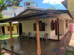 ein kleines Haus mit einer Terrasse mit Stühlen in der Unterkunft Cinnamon Villa AMBA in Ambalangoda