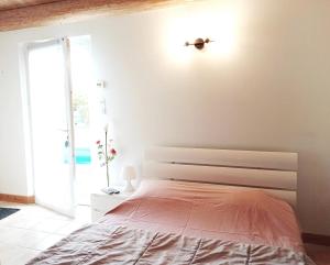 ein weißes Schlafzimmer mit einem Bett und einem Fenster in der Unterkunft Charmant appartement avec jardin et piscine à La Jarrie in La Jarrie + 13 Fotos