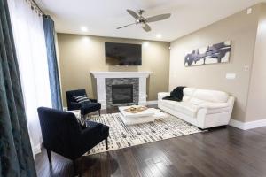 ein Wohnzimmer mit einer weißen Couch und einem Kamin in der Unterkunft Luxurious home, Sleeps 13, Minutes off Anthony Henday, Shopping, Restaraunts, Casino in Edmonton
