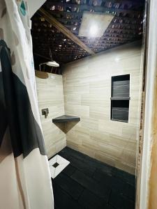 ein Bad mit einer Dusche und einem schwarz-weißen Fliesenboden in der Unterkunft Casa Maria in El Cebollito