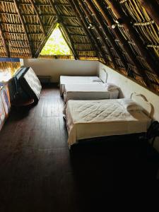 três camas num quarto com uma janela em Casa Maria em El Cebollito