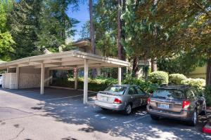 two cars parked in a parking lot in front of a building at 115 Modern and Serene Min to Downtown in Bellevue