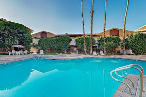 a swimming pool with blue water in front of a house at Mountains & Palms #5648 in Palm Springs
