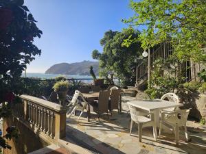 a patio with a table and chairs and the ocean at Villa fronte mare in Levanto