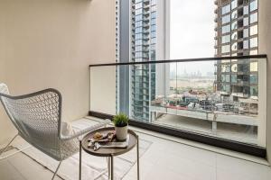 krzesło i stół w pokoju z dużym oknem w obiekcie Frank Porter - Wilton Terraces 1 w Dubaju