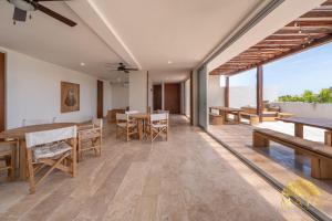 a dining room with tables and chairs and a view of the ocean at NHOA 206A Lux 2BR Condo Jungle View in Aldea Zama in Tulum