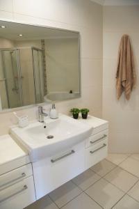 a white bathroom with a sink and a mirror at Spacious 2 Bed 2 Bath Home in one of Sides Most Popular Communities in Side